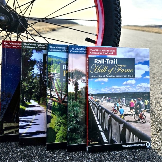 picture of books against a bike tire on a bike trail.